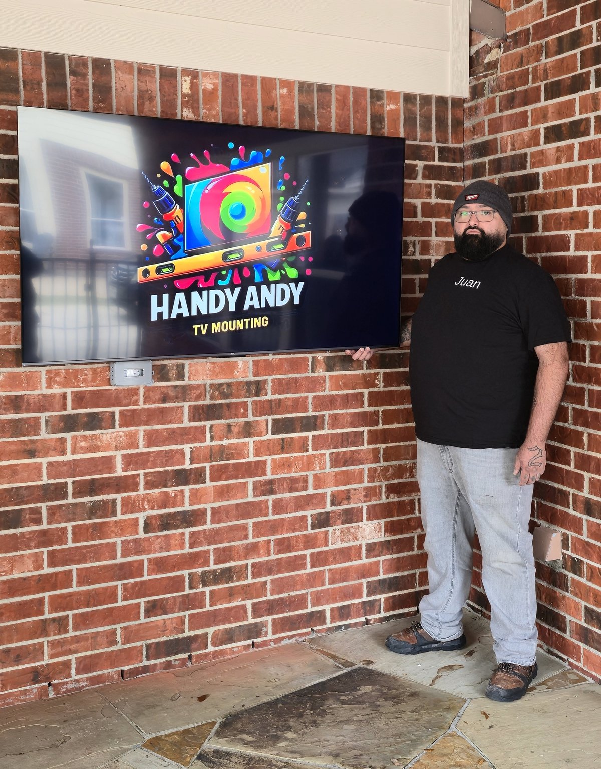 TV mounted on brick outdoors by Handy Andy TV Mounting