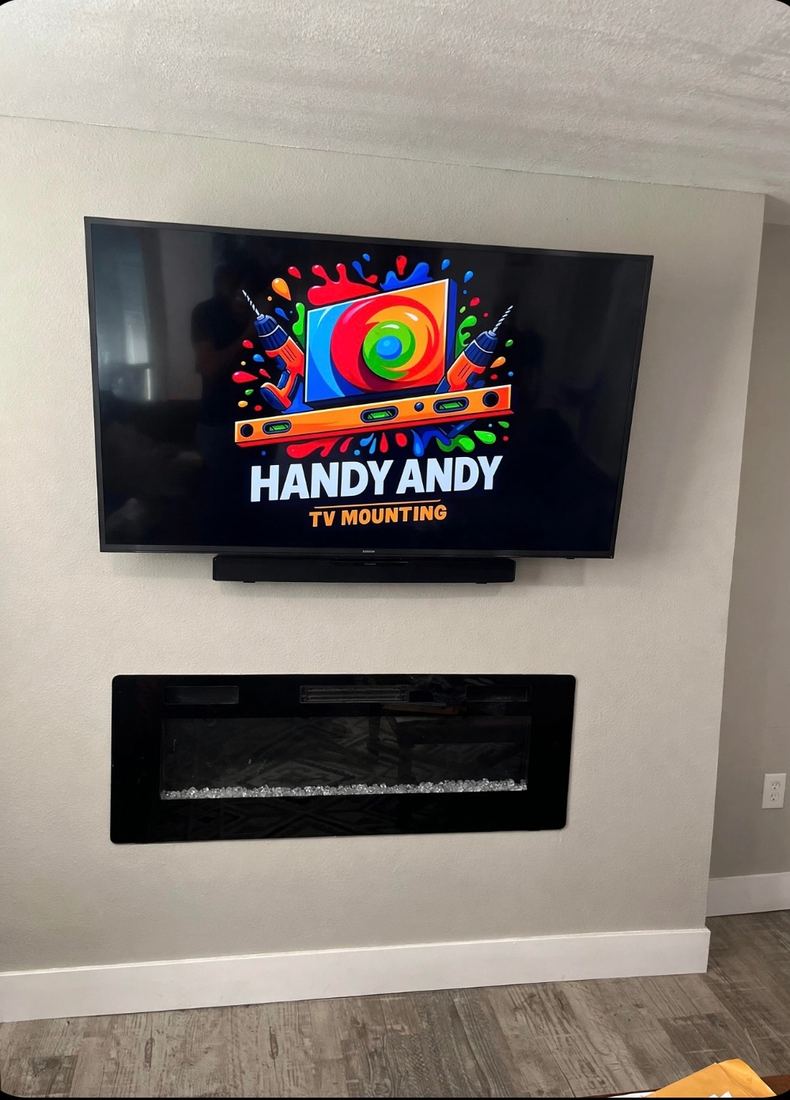 TV and soundbar mounted on a gray wall above a built-in electric fireplace