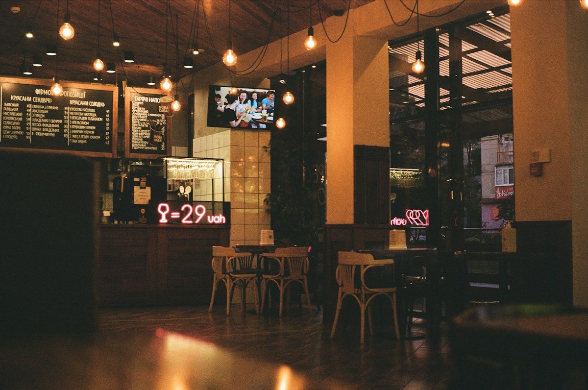 Restaurant at night with menu boards and a screen above the counter