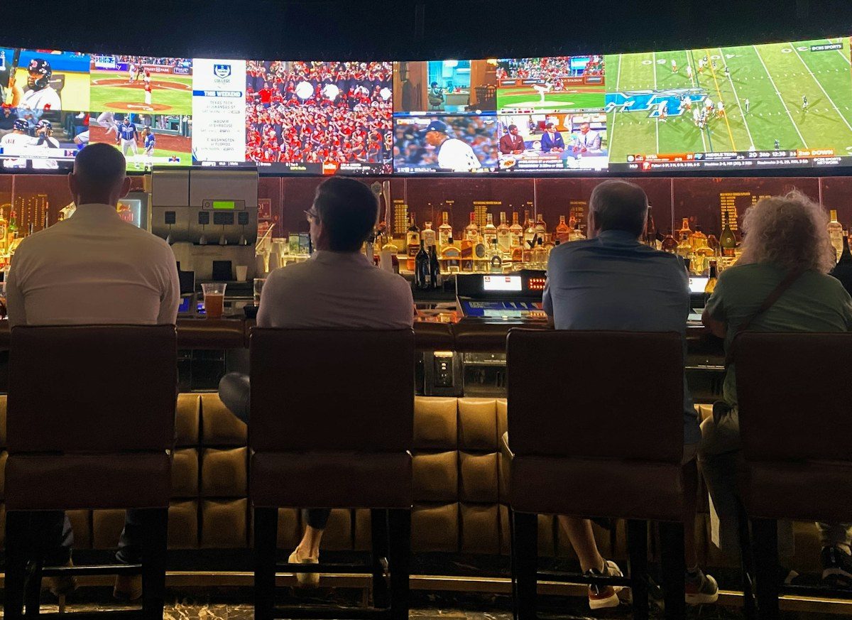 Sports bar with a wide wall of TV screens above the bar