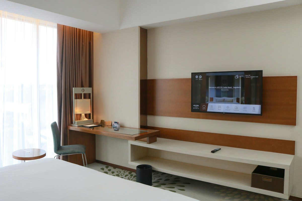 Hotel room with a TV mounted on a wood panel wall
