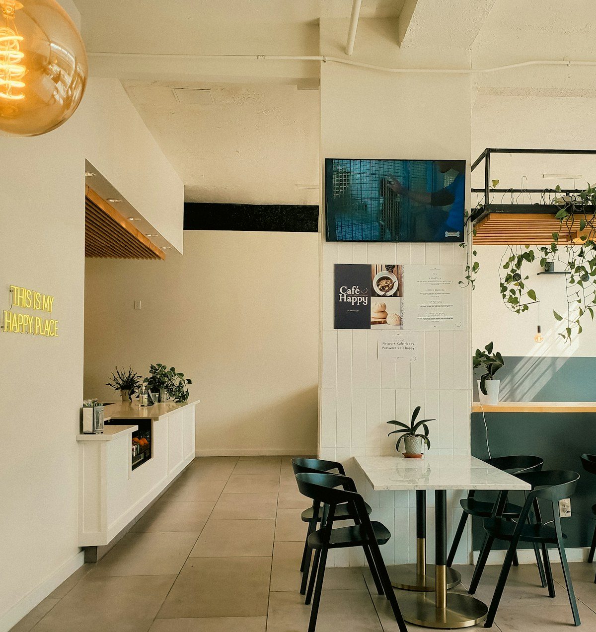 Cafe with a TV mounted on a white wall above the tables