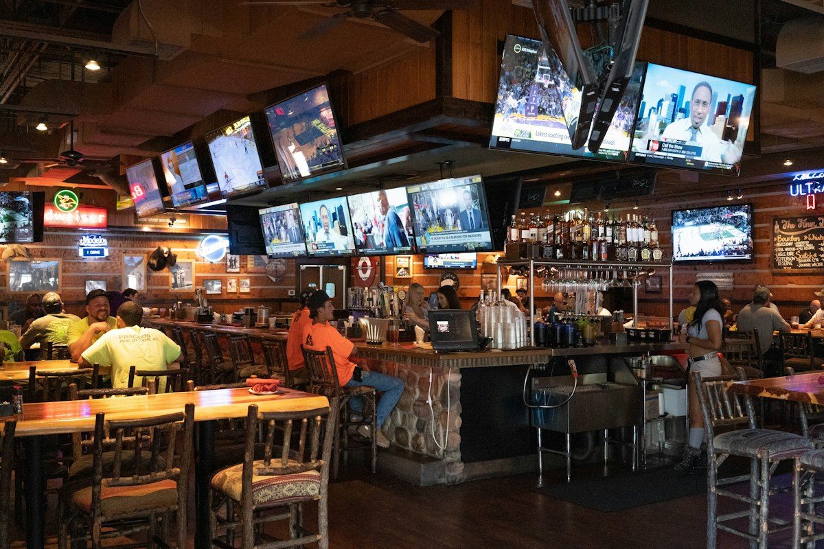 Sports bar with many TVs mounted above the bar