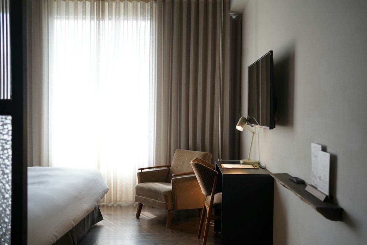 Hotel room with a TV mounted on the wall beside the desk