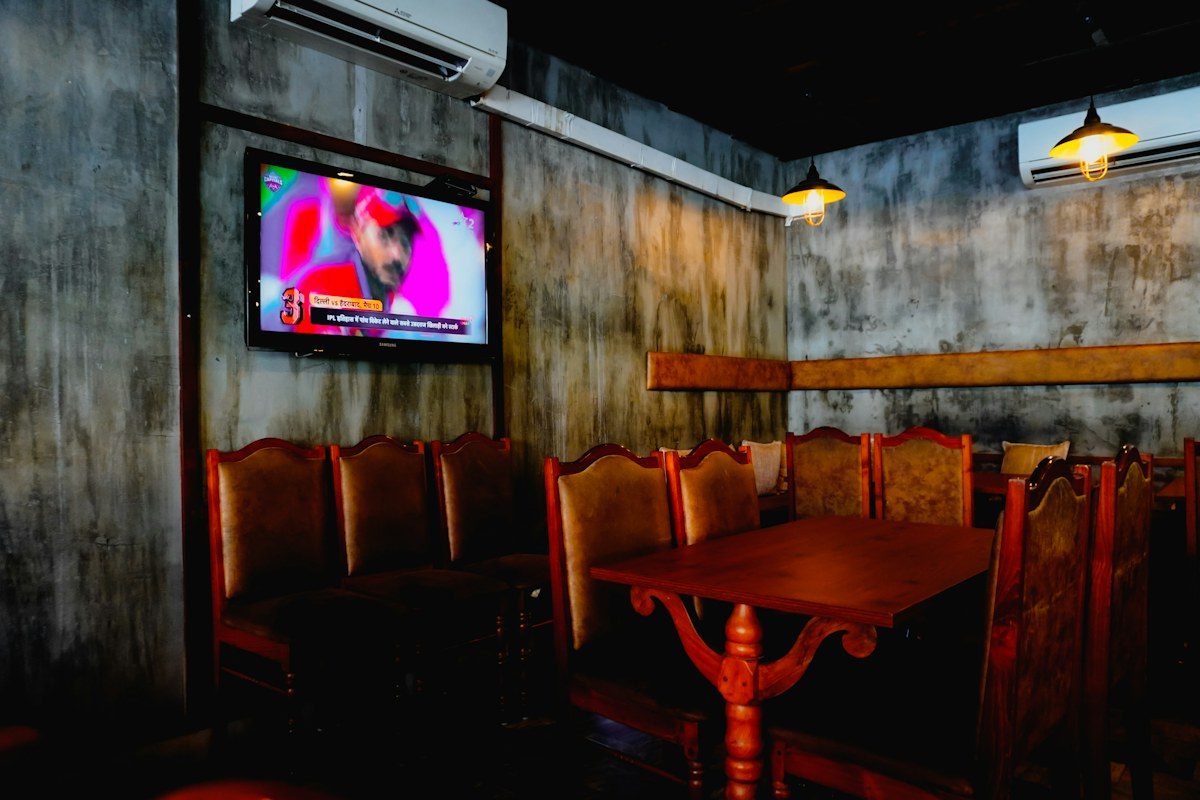 Restaurant dining room with a TV mounted on the wall above booth seating