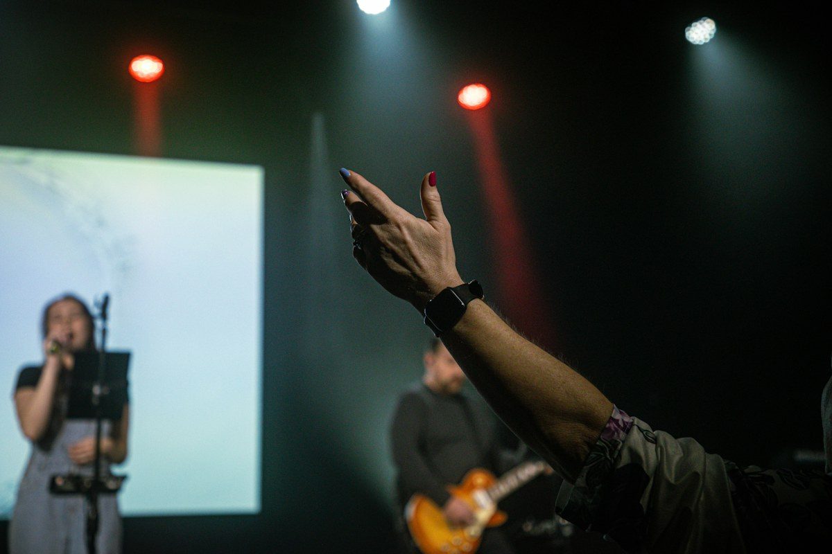 Worship singer on stage with a projection screen behind her