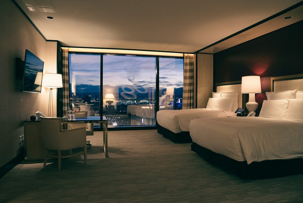 Hotel room with two beds and a wall-mounted TV