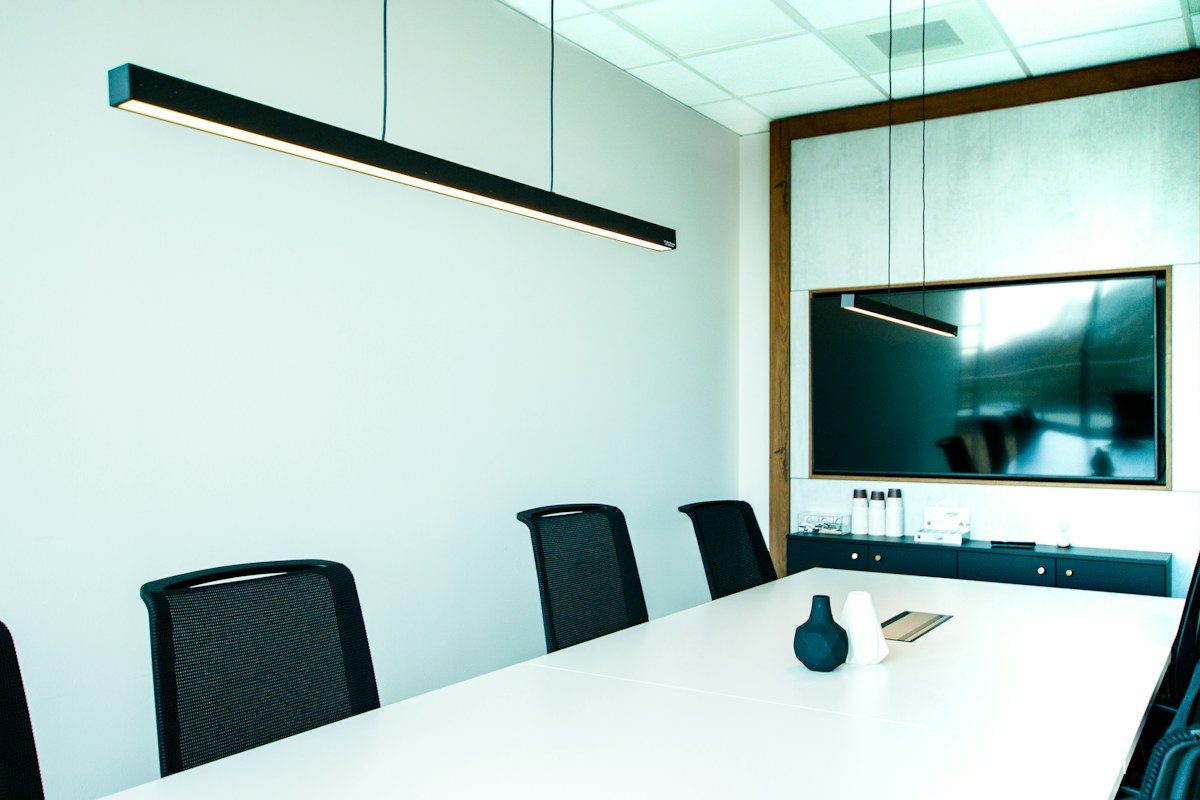 Conference room with a wall-mounted display at the end of the table