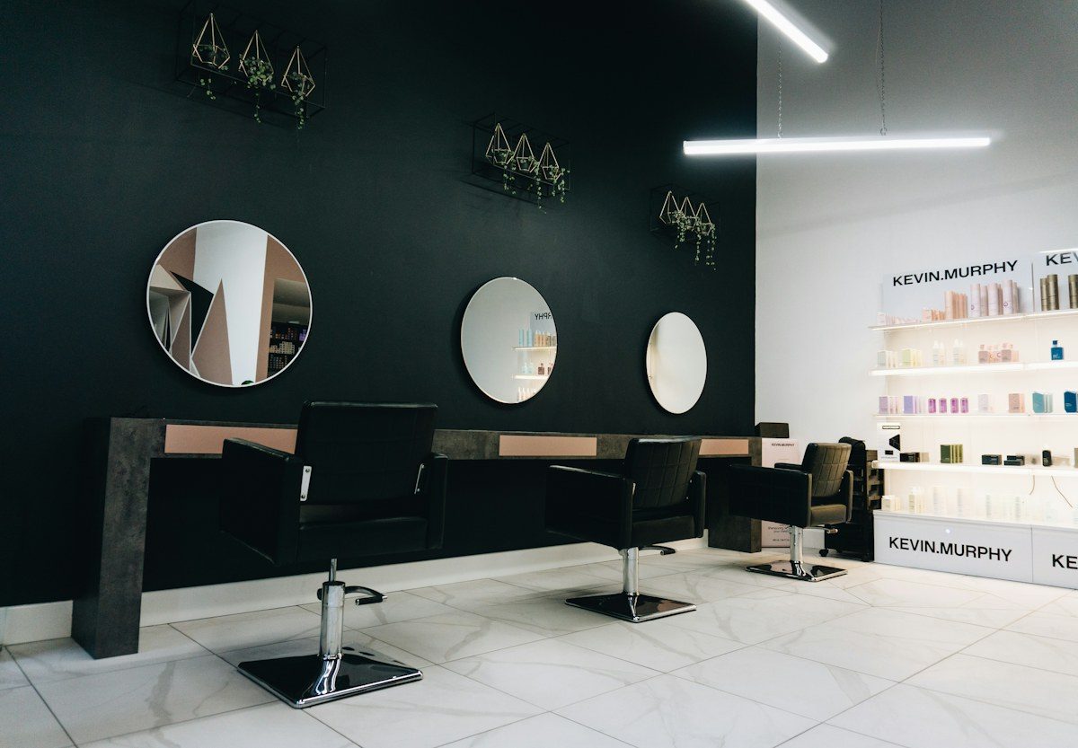 Hair salon with round mirrors and black chairs