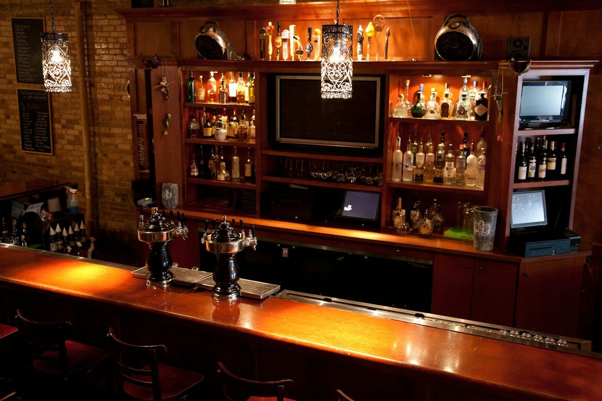 Wood bar with a TV built into the back bar shelving