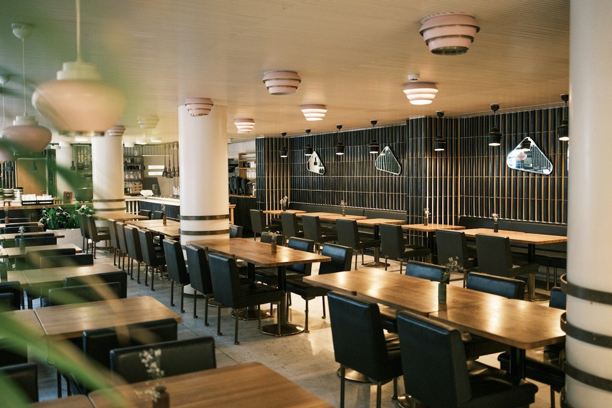 Large restaurant dining room with long wooden tables