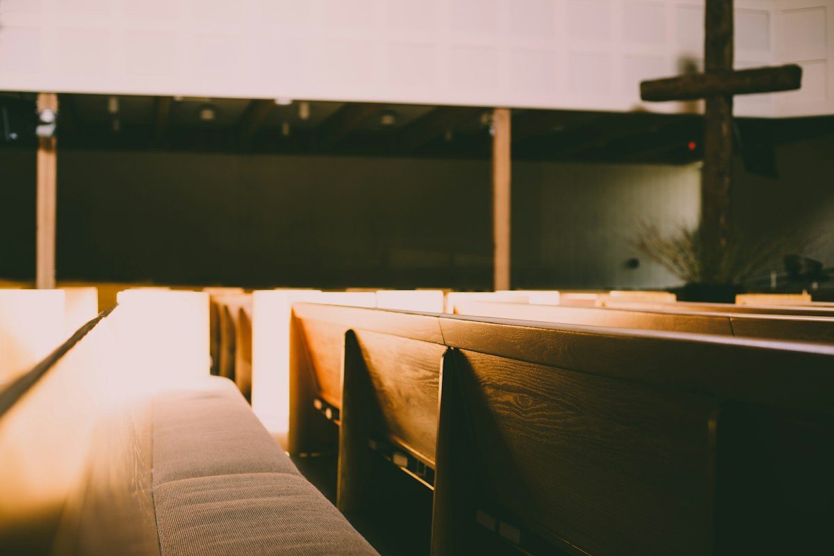 Church pews facing a cross at the front