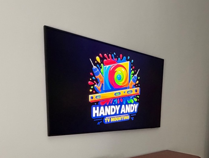 Flat TV bracket mounting a TV flush to the wall above a dresser, installed by Handy Andy