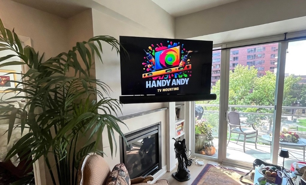 Full motion TV bracket pulling a TV out from a fireplace wall and swiveling it toward the room, installed by Handy Andy