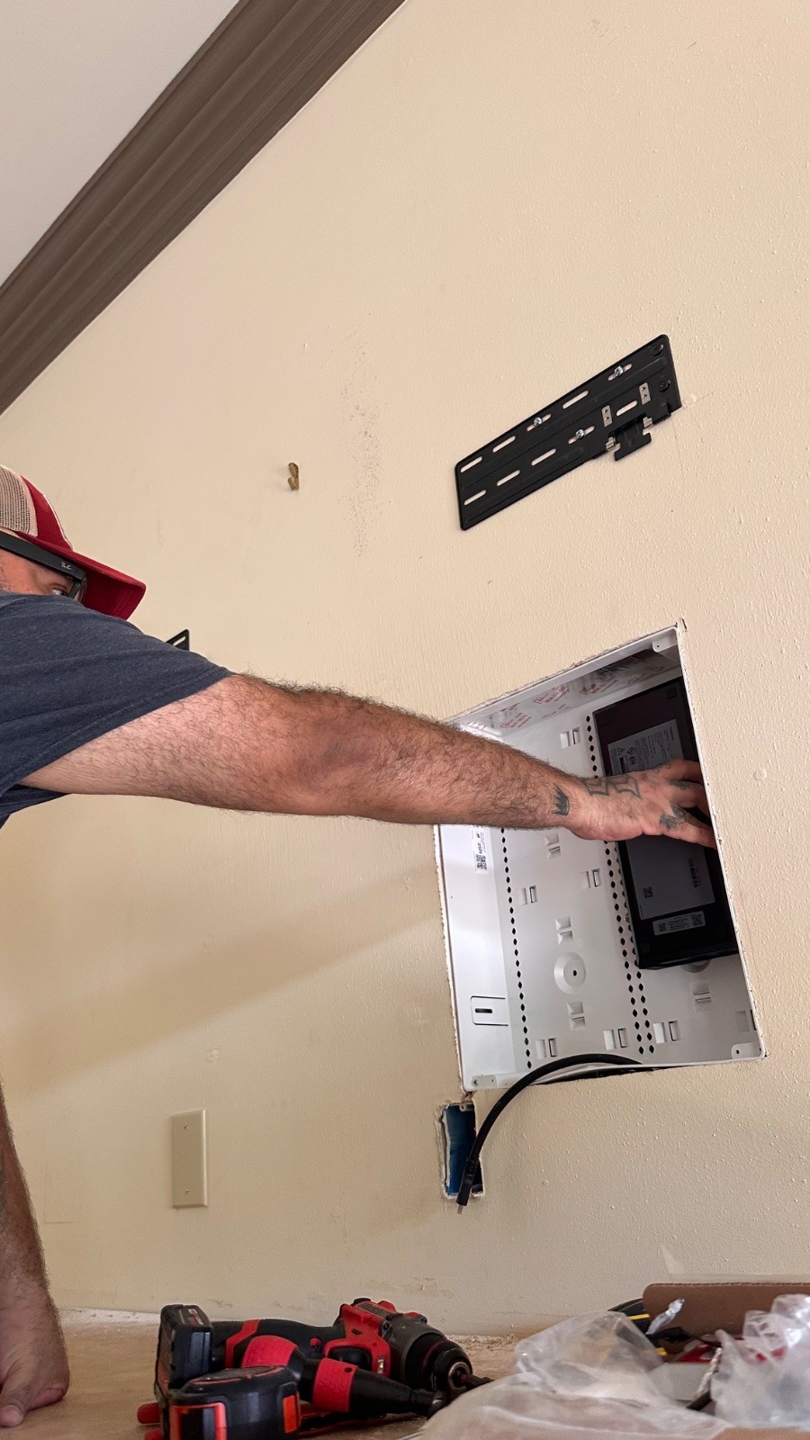 Juan placing the Samsung One Connect box inside the recessed enclosure