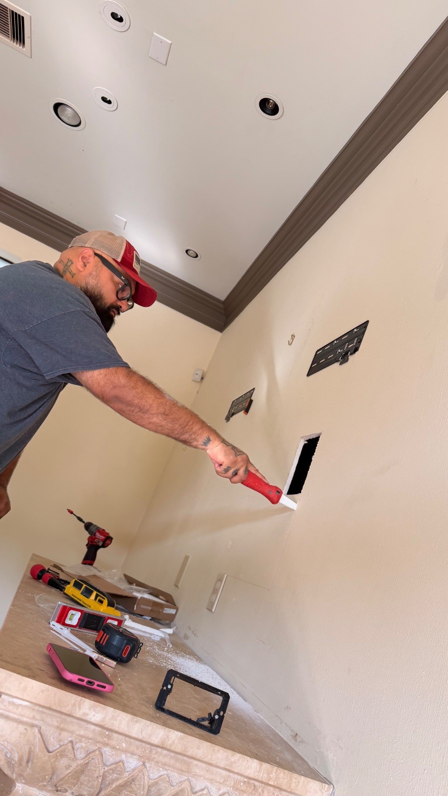 Juan opening the drywall for the Samsung One Connect box