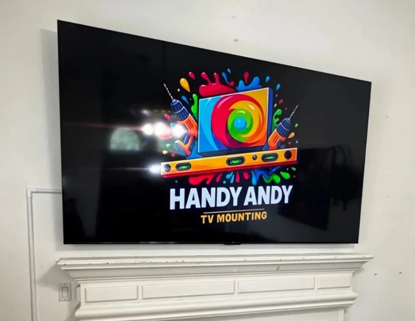 Tilting TV bracket angling a TV above a fireplace mantel, installed by Handy Andy